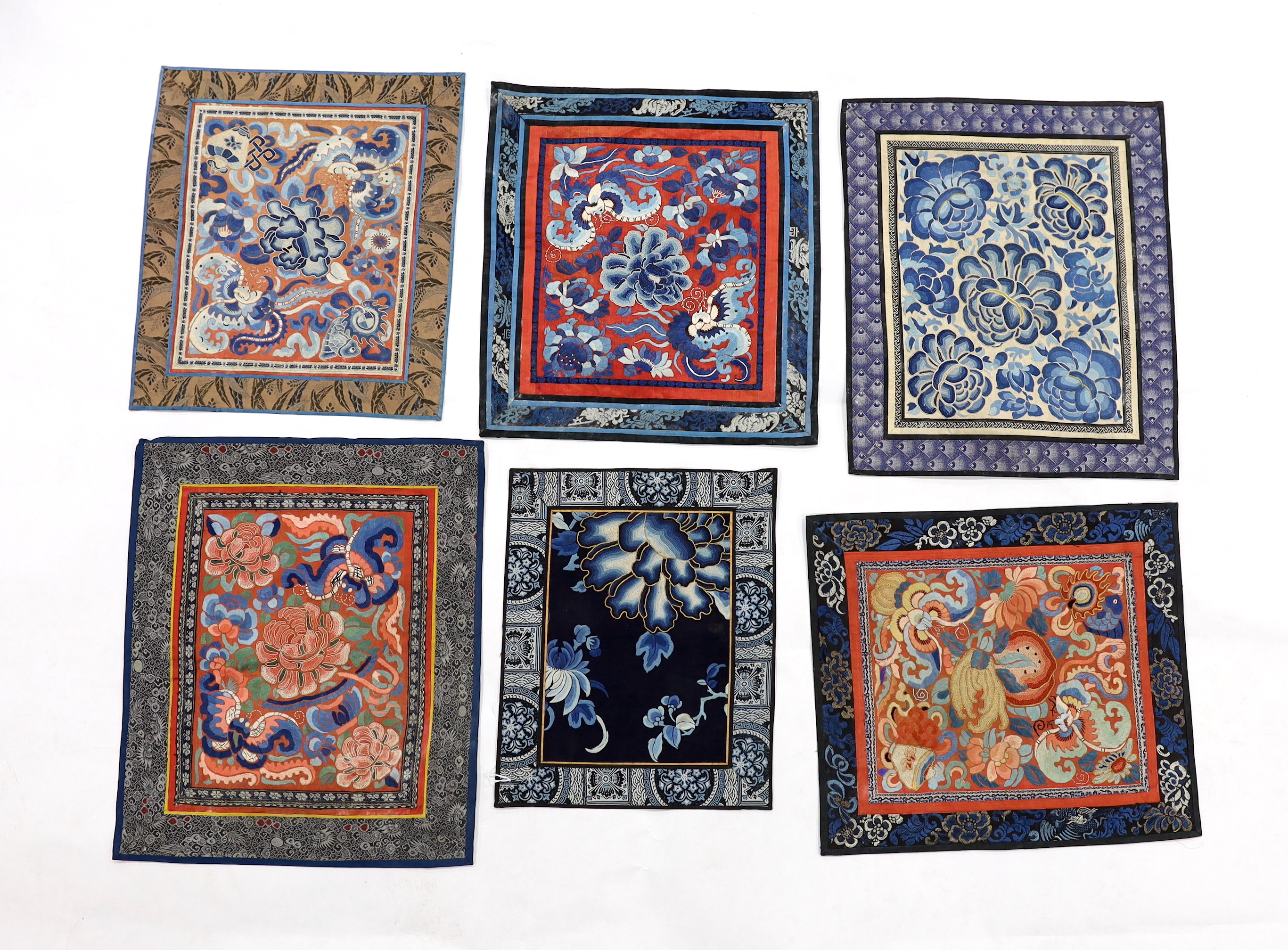 Six large Chinese silk embroidery mats with silk brocade borders, mostly embroidered flowers and butterflies in stem stitch and Beijing knot, largest 44.5cm x 37cm